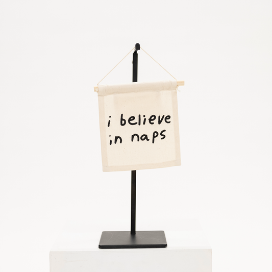 a canvas wall hanging with phrase i believe in naps