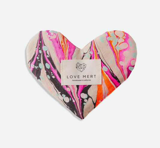 Heart-shaped eye pillow with colorful pattern and 'LOVE MERT' label on a white background