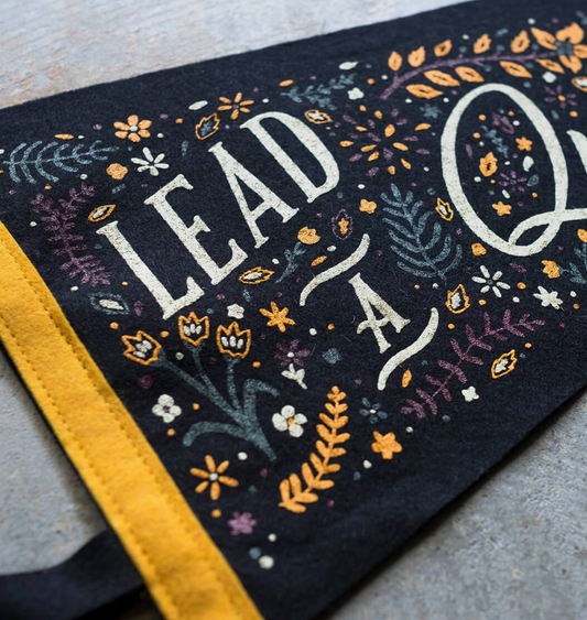 Decorative pennant with floral patterns and text on a textured surface