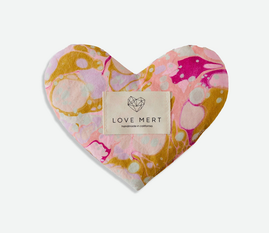 Heart-shaped eye pillow with marbled pattern and 'LOVE MERT' label on a white background