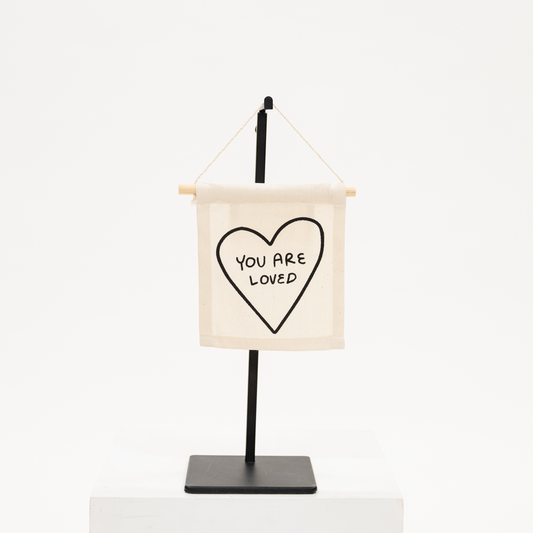 a wall canvas sign with phrase you are loved