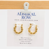 Gold hoop earrings on a Admiral Row branded card.