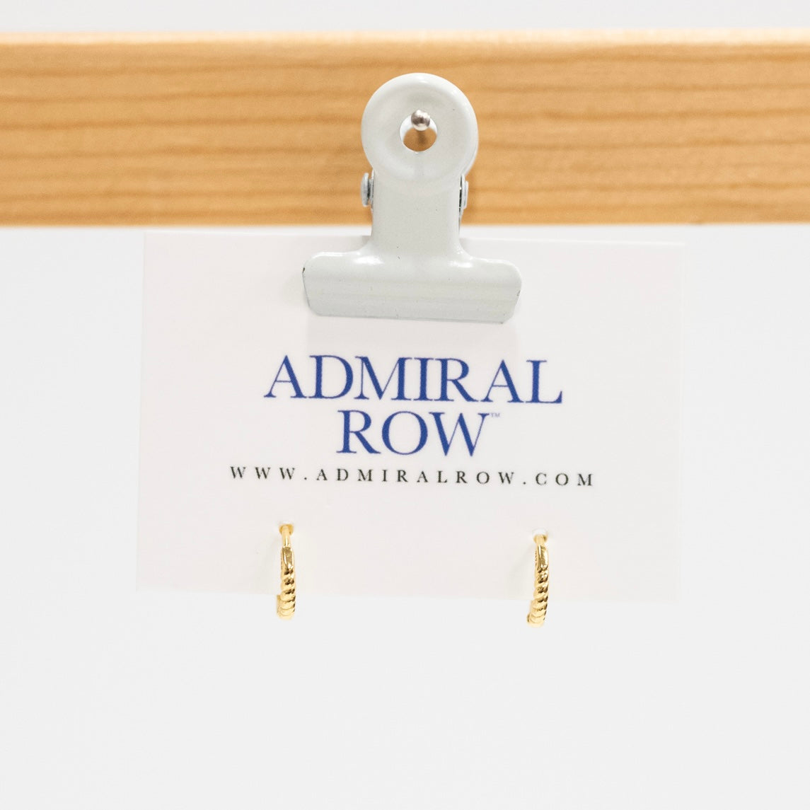 Gold hoop earrings on a white card with 'Admiral Row' branding.