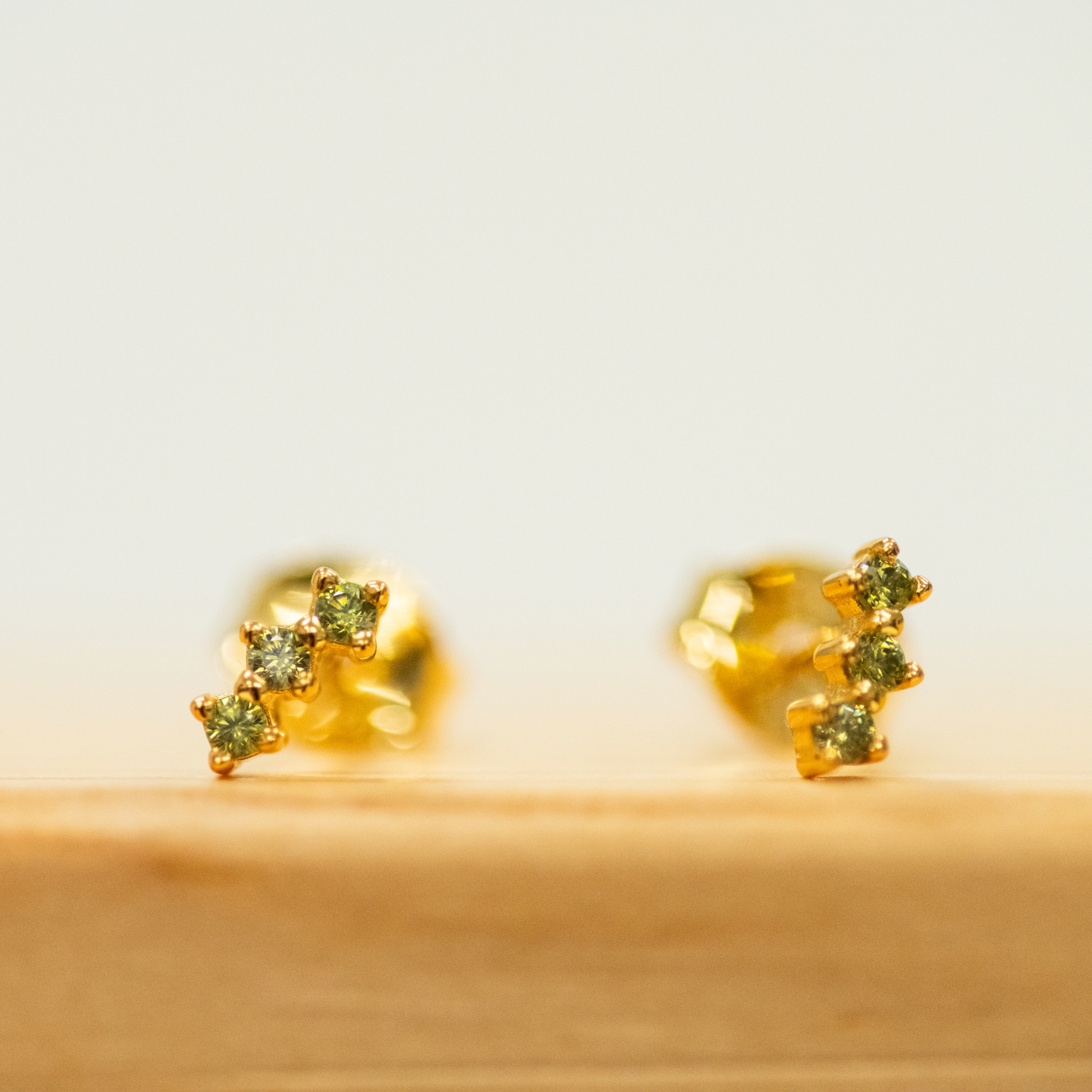 Olive Green Stud Earrings with three gems for a slight curve stud earring set in gold