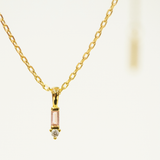 Gold necklace with a small pendant on a white background