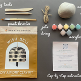 DIY air dry clay kit with tools and materials on a gray background