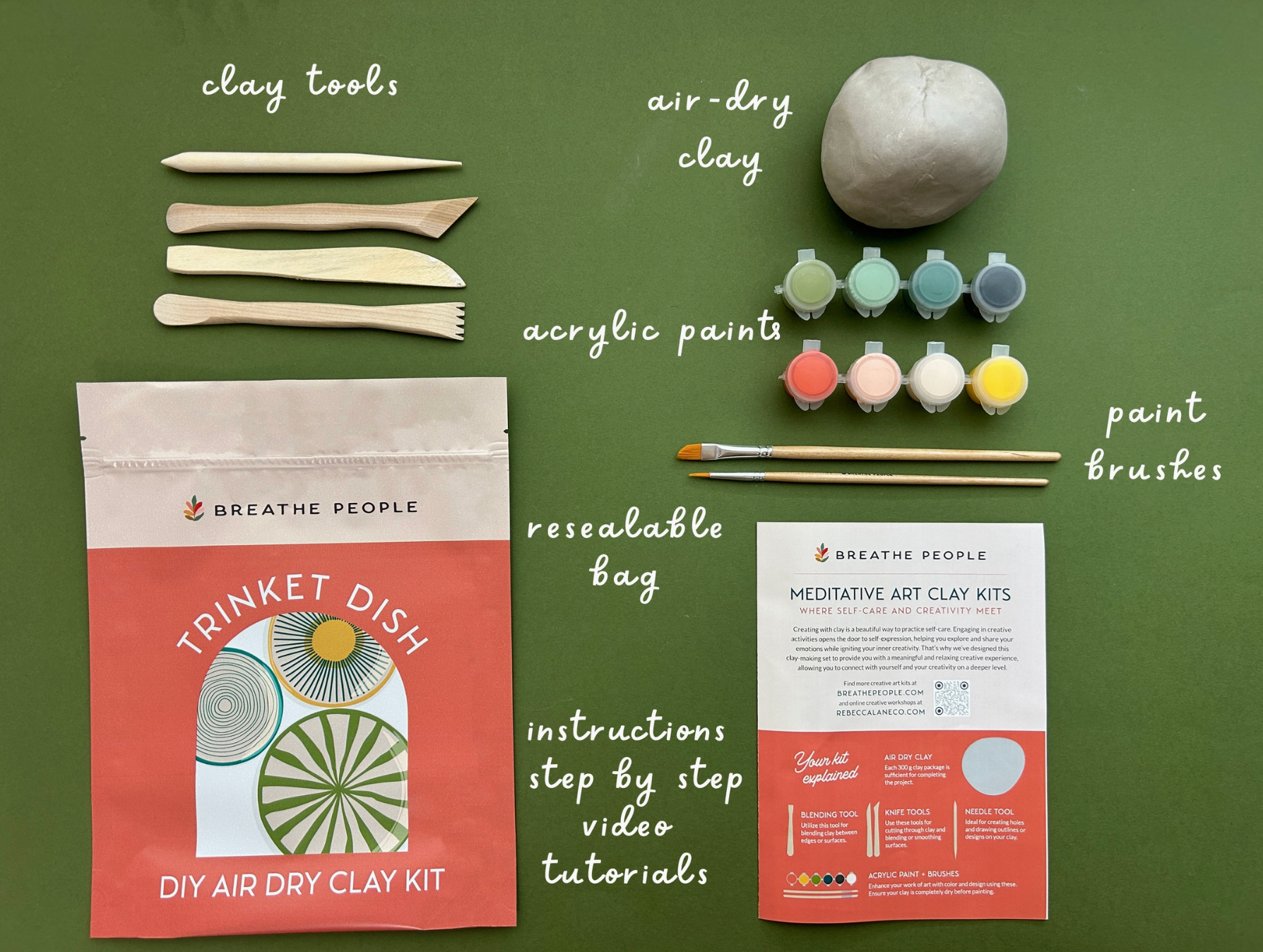 Meditative art clay kit with tools, air-dry clay, acrylic paints, and a resealable bag on a green background.