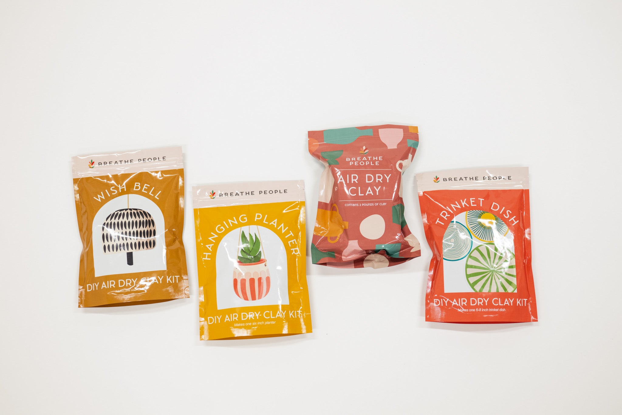 Four air dry clay kits with colorful packaging on a white background