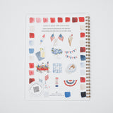 A spiral-bound watercolor painting guide book with a patriotic red, white, and blue theme, featuring illustrations of American flags, an ice cream cone, a wagon, and bunting on a white cover.