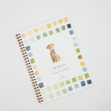 A spiral-bound watercolor workbook titled 'Animals' featuring a watercolor illustration of a dog in the center, surrounded by a border of watercolor paint swatches in various colors on a white cover.