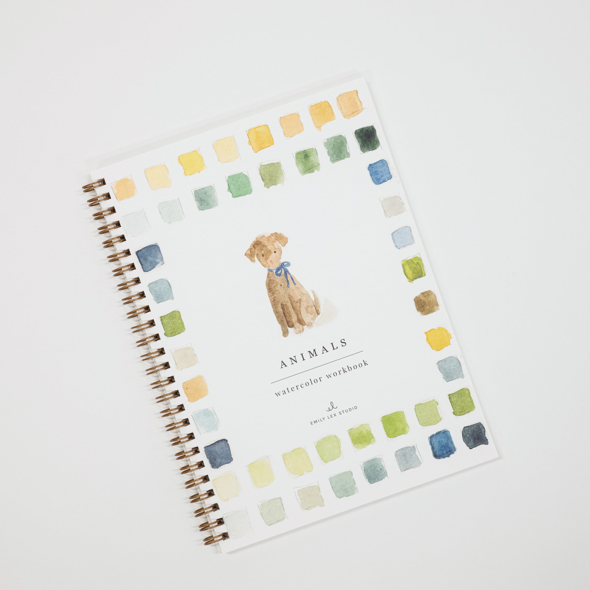 A spiral-bound watercolor workbook titled 'Animals' featuring a watercolor illustration of a dog in the center, surrounded by a border of watercolor paint swatches in various colors on a white cover.