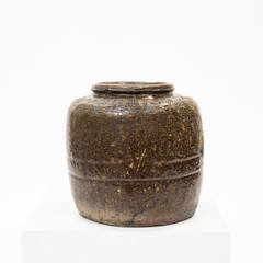 A vintage brown ceramic bean pot with a textured surface, isolated on a white background.