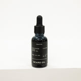Black bottle of beard oil with dropper on a white background