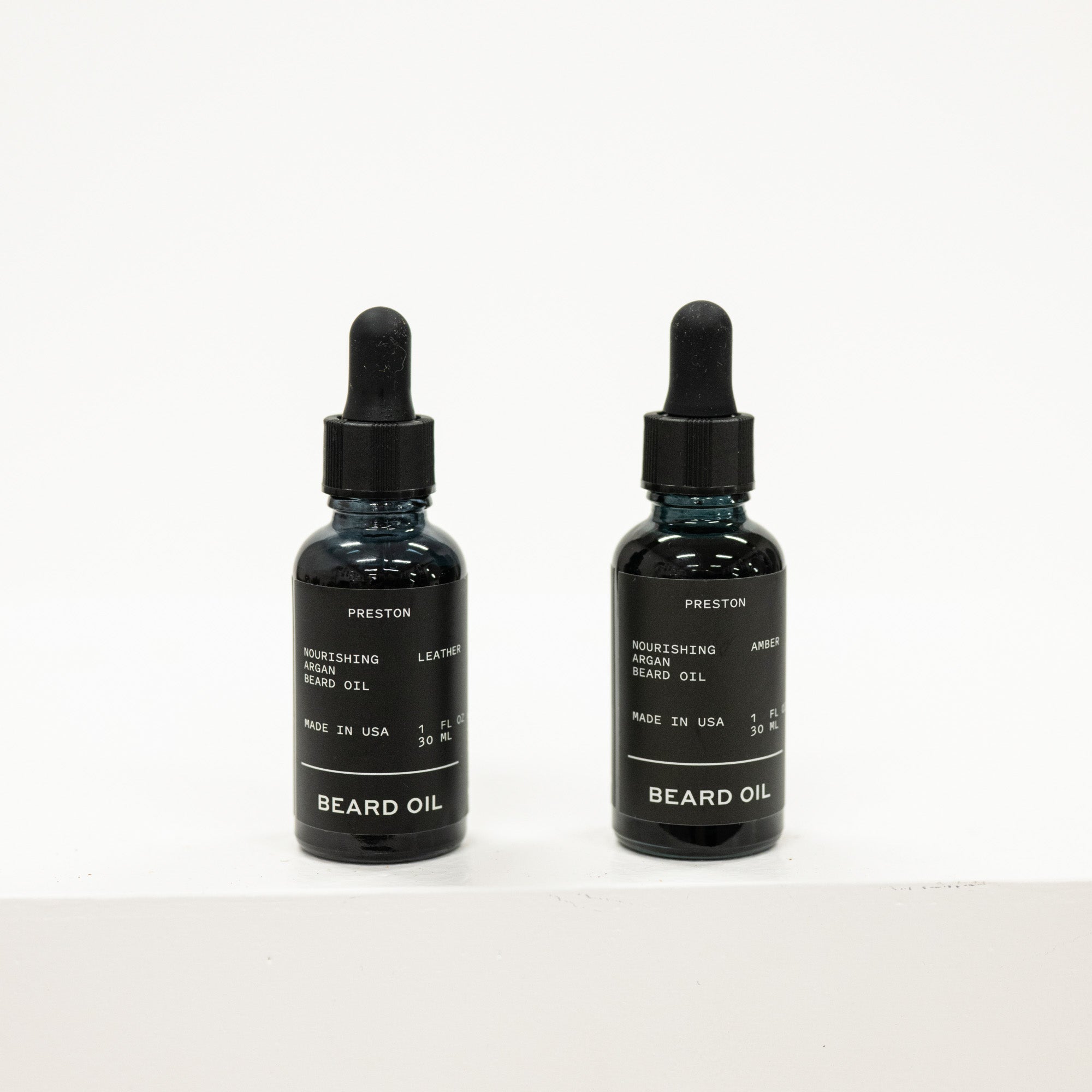 Two bottles of Preston Beard Oil on a white background