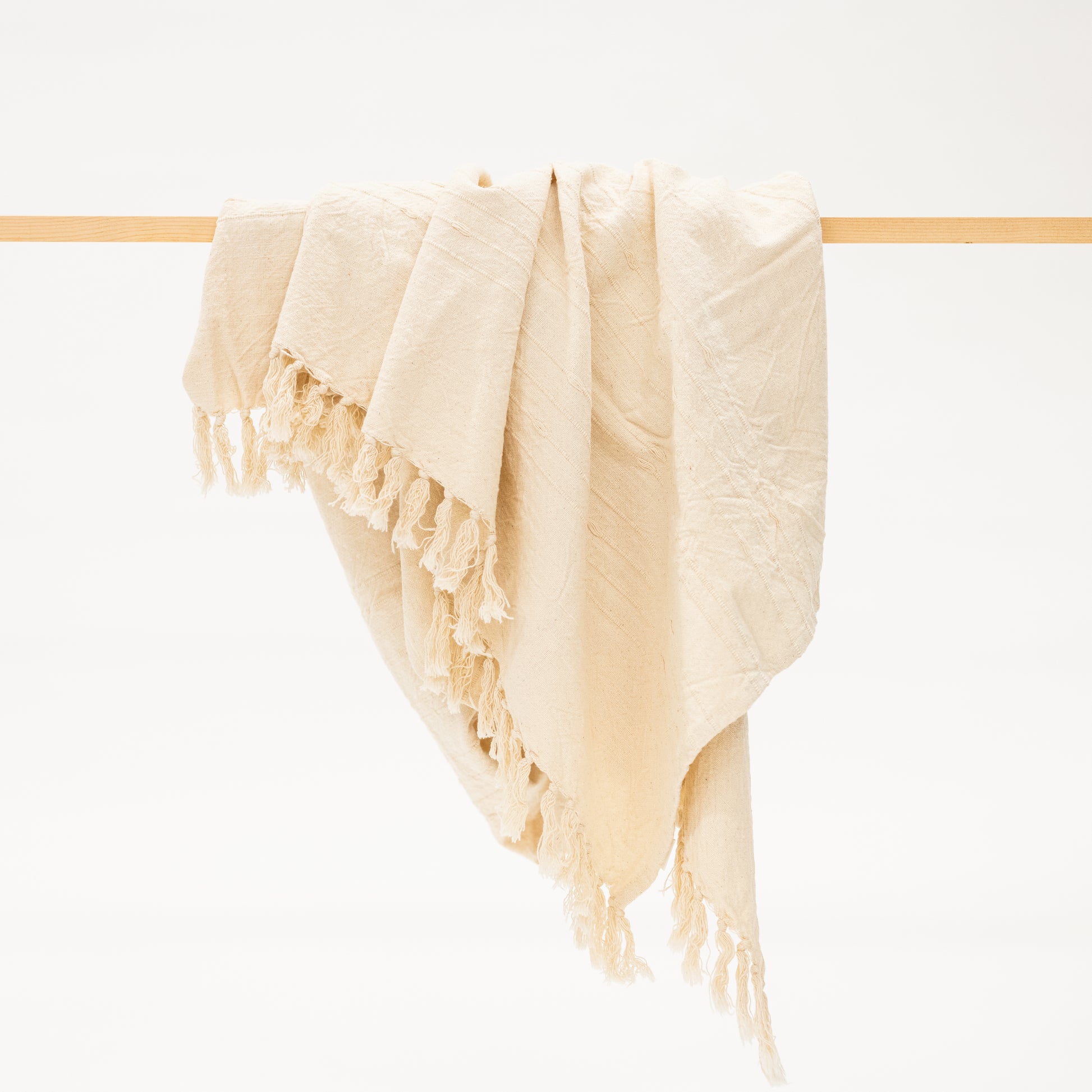 beige cotton throw blanket with tassels