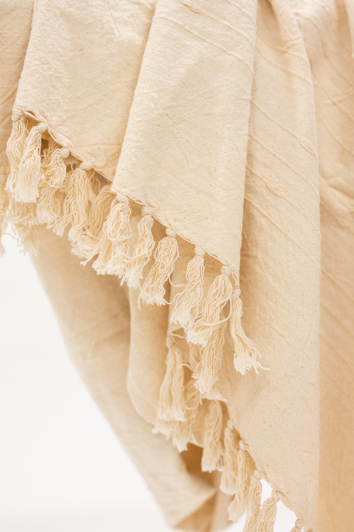 beige cotton throw blanket with tassels