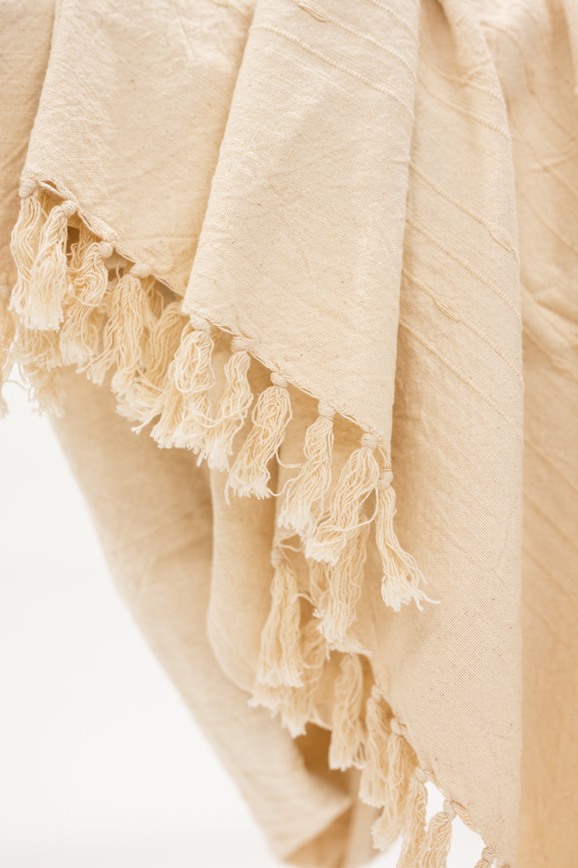 beige cotton throw blanket with tassels