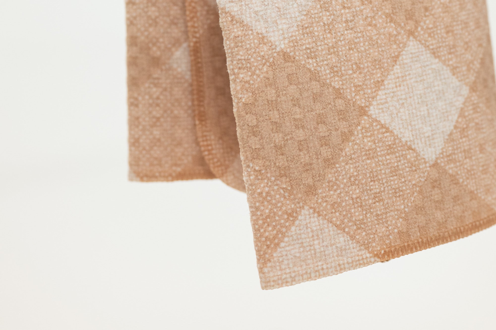 Folded fabric with a diamond pattern on a light background