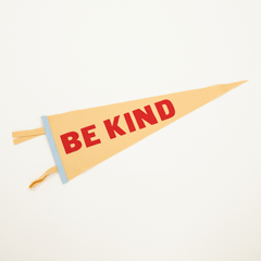 cream and light blue felt pennant with words "be kind" in red screen print