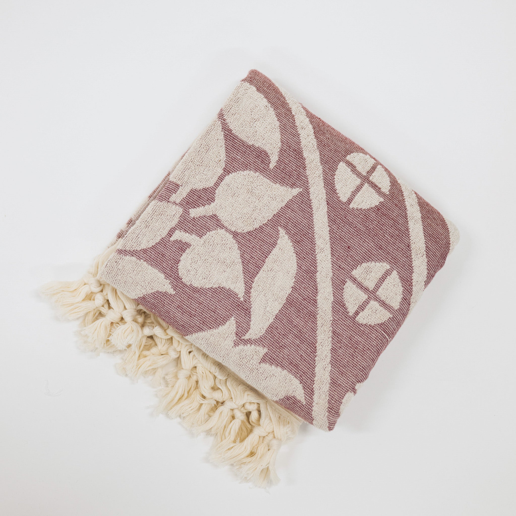 Decorative beach towel with mandala pattern and tassels on a white background