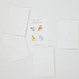 A set of white art cards featuring watercolor bird illustrations, arranged on a light gray background. One card in the center shows four colorful watercolor birds, while the surrounding cards display simple line drawings of birds.