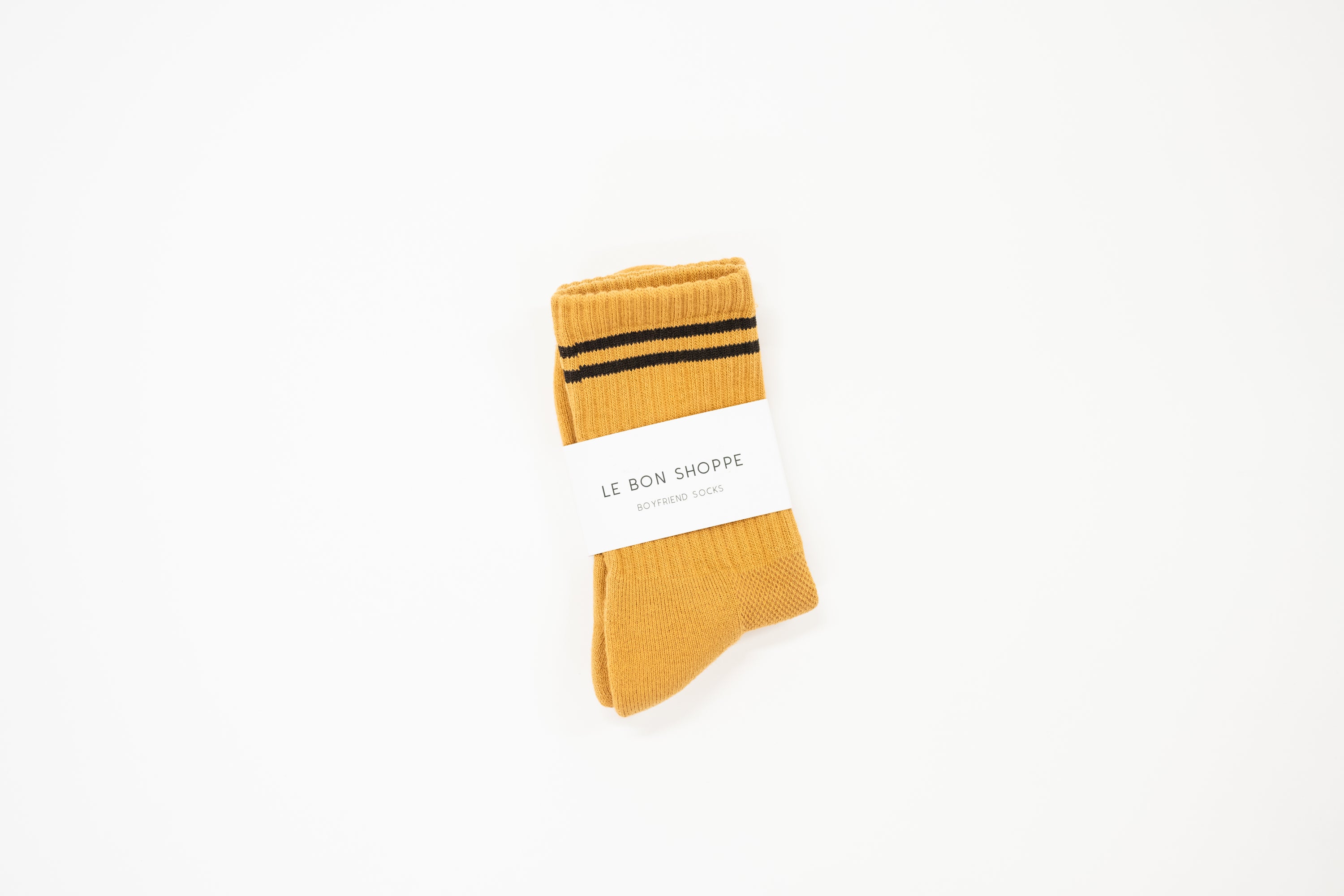 mustard yellow tall crew sock with a white label saying le bon shoppe