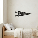 Decorative wall pennant with motivational quote above a bed in a bedroom.