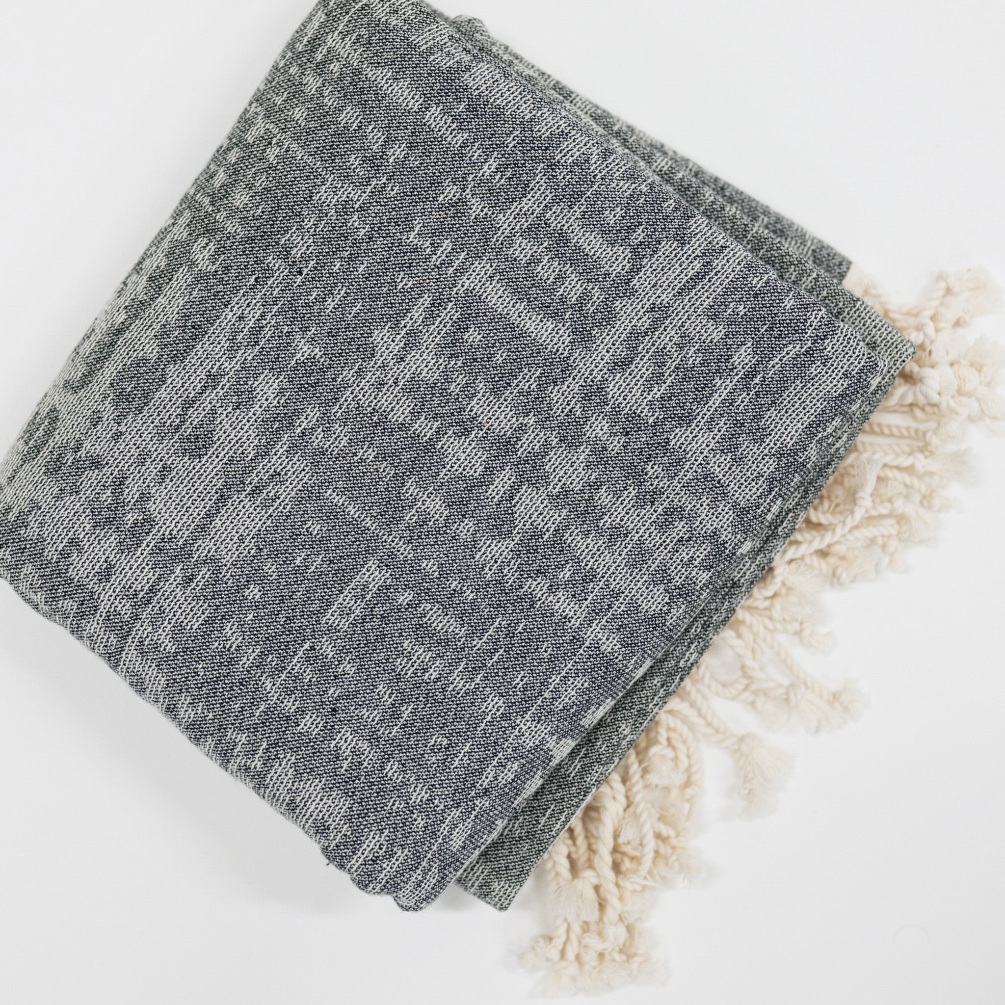 Gray textured beach towel on a white surface