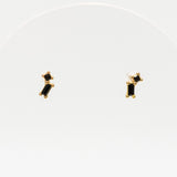 Pair of gold earrings with black stones on a white background