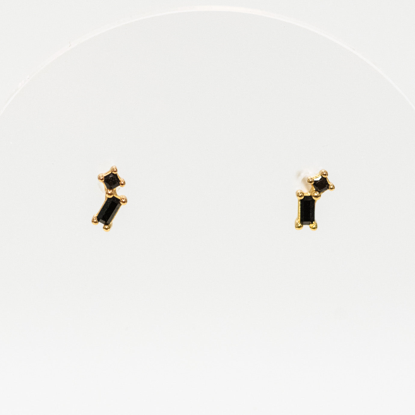 Pair of gold earrings with black stones on a white background