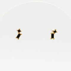 Pair of gold earrings with black stones on a white background