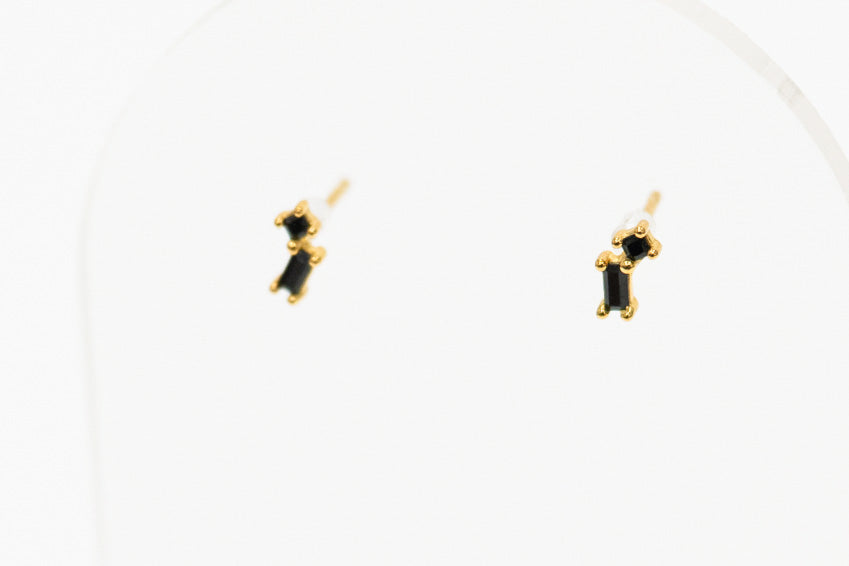 Pair of gold earrings with black stones on a white background