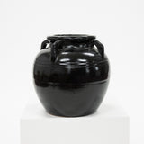 Black ceramic jar with handles on a white background