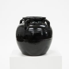Black ceramic jar with handles on a white background