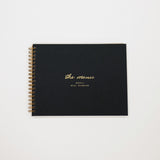Black planner with gold text on a white background