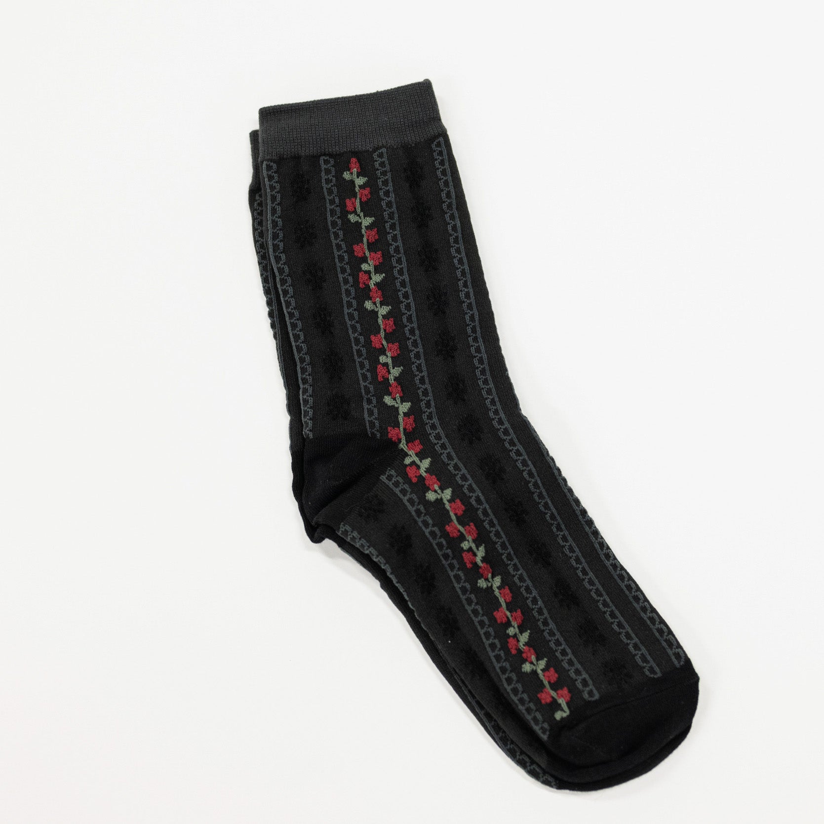 Black colored crew socks featuring scalloped stripes and a stripe of flowers.