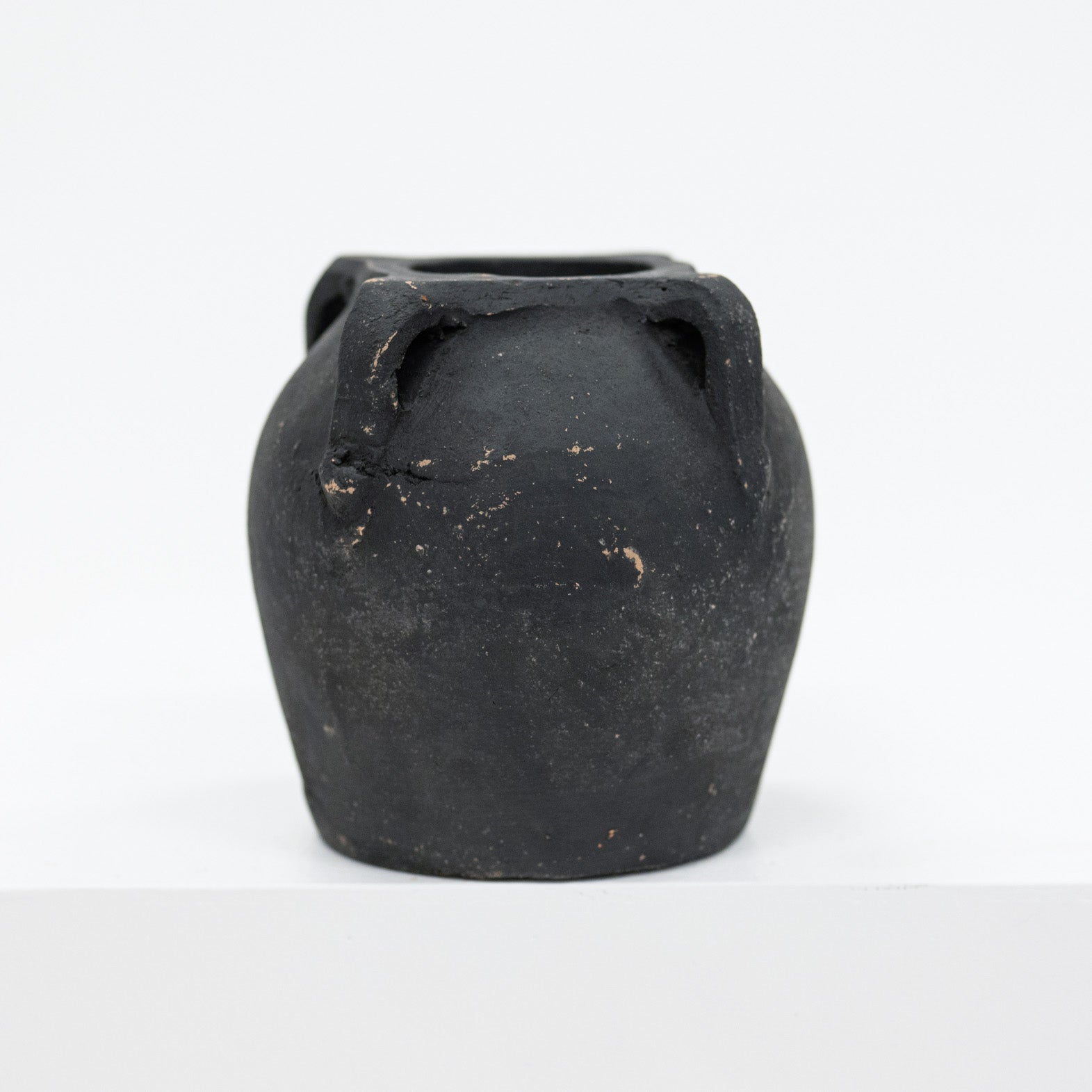 Black ceramic vase with handles on a white background