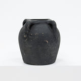 Black ceramic vase with handles on a white background