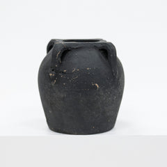 Black ceramic vase with handles on a white background