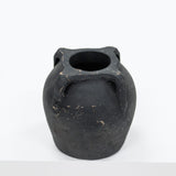 Black ceramic vase with three handles on a white background