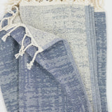 Blue crosshatch pattern beach towel with tassels on a white background