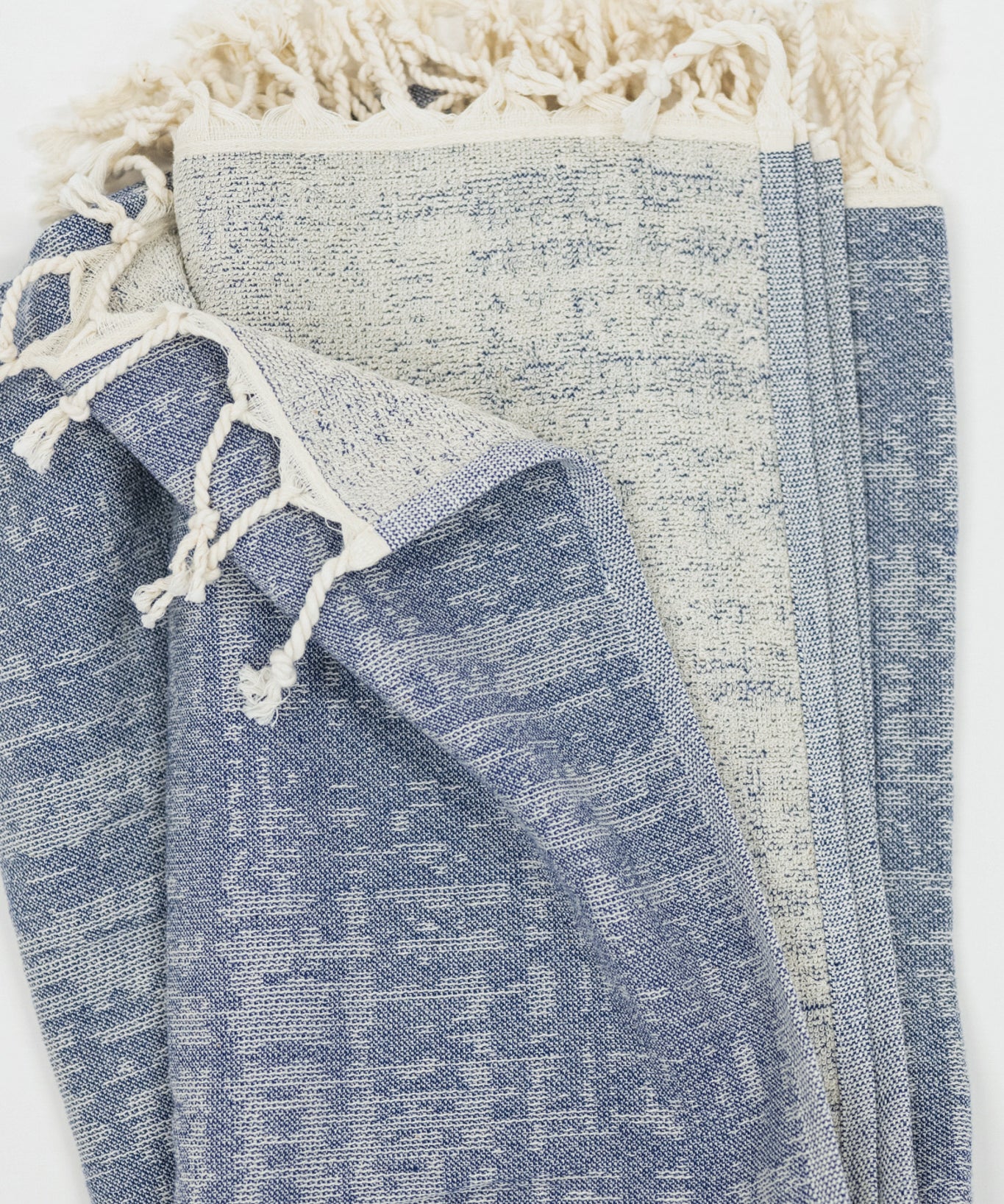 Blue crosshatch pattern beach towel with tassels on a white background
