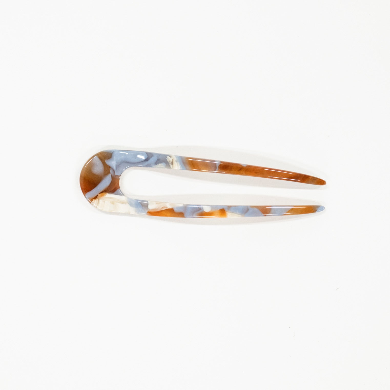 Marbled patterned hair clip on a white background