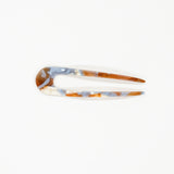 Marbled patterned hair clip on a white background