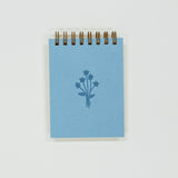 Small blue notebook with a floral design on a white background