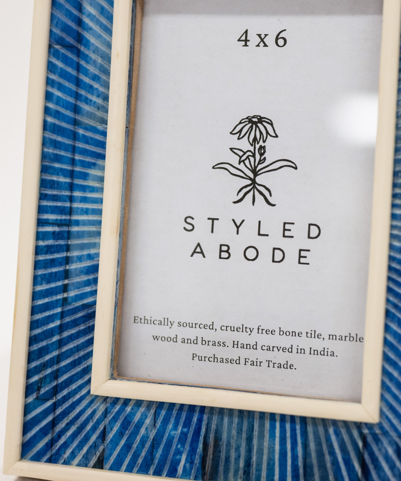 Framed picture with 'Styled Abode' branding and product details on a blue striped background.