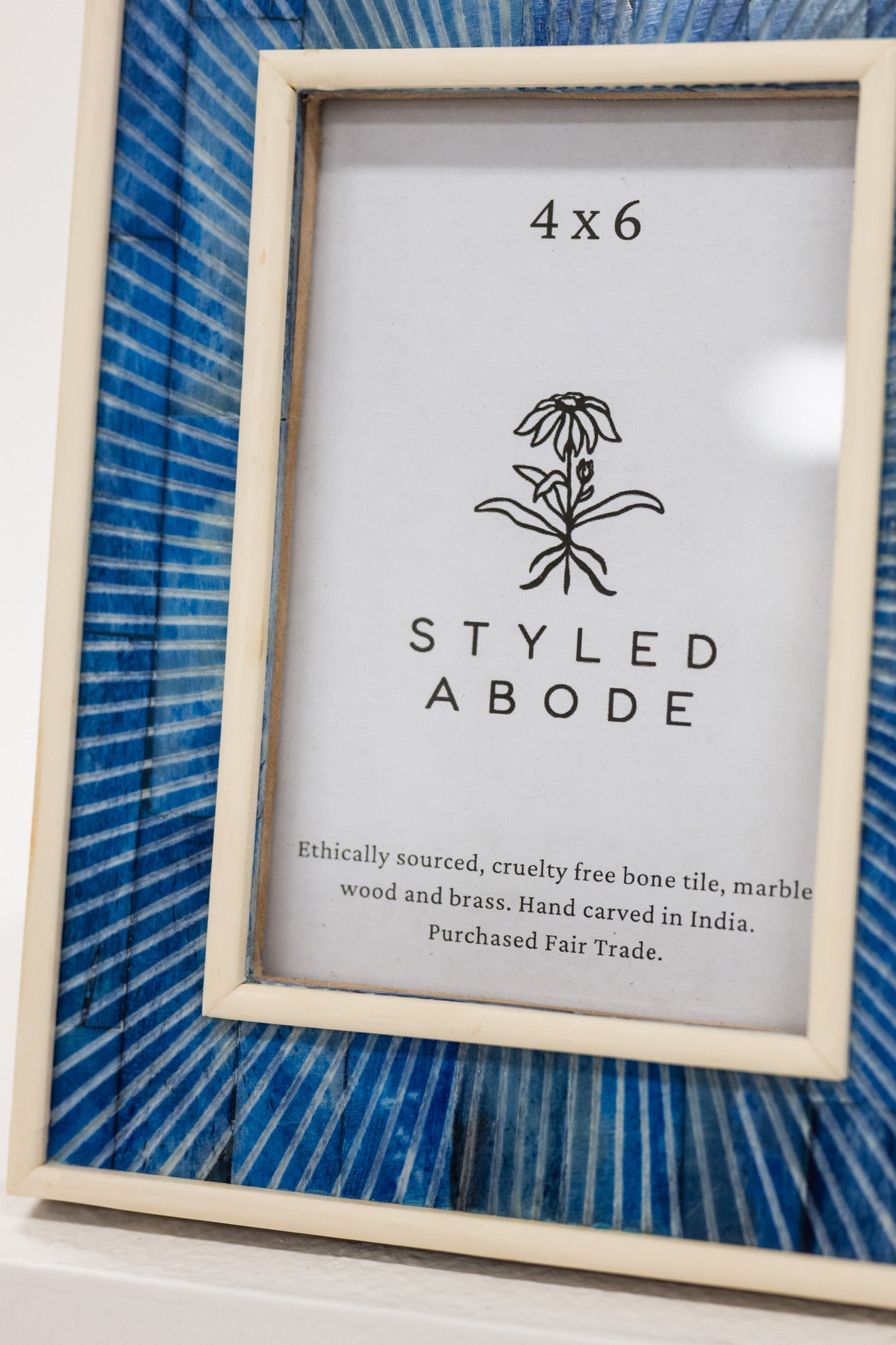 Framed picture with 'Styled Abode' branding and product details on a blue striped background.