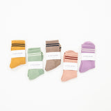 A selection of striped boyfriend style socks in various colors, each with a label showing the name Le Bon Shoppe.