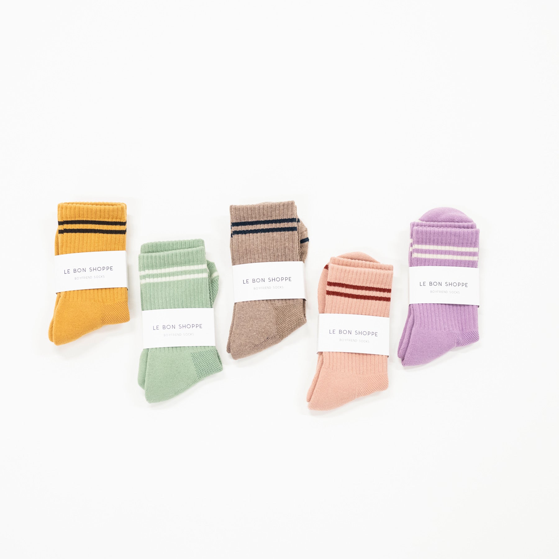 A selection of striped boyfriend style socks in various colors, each with a label showing the name Le Bon Shoppe.