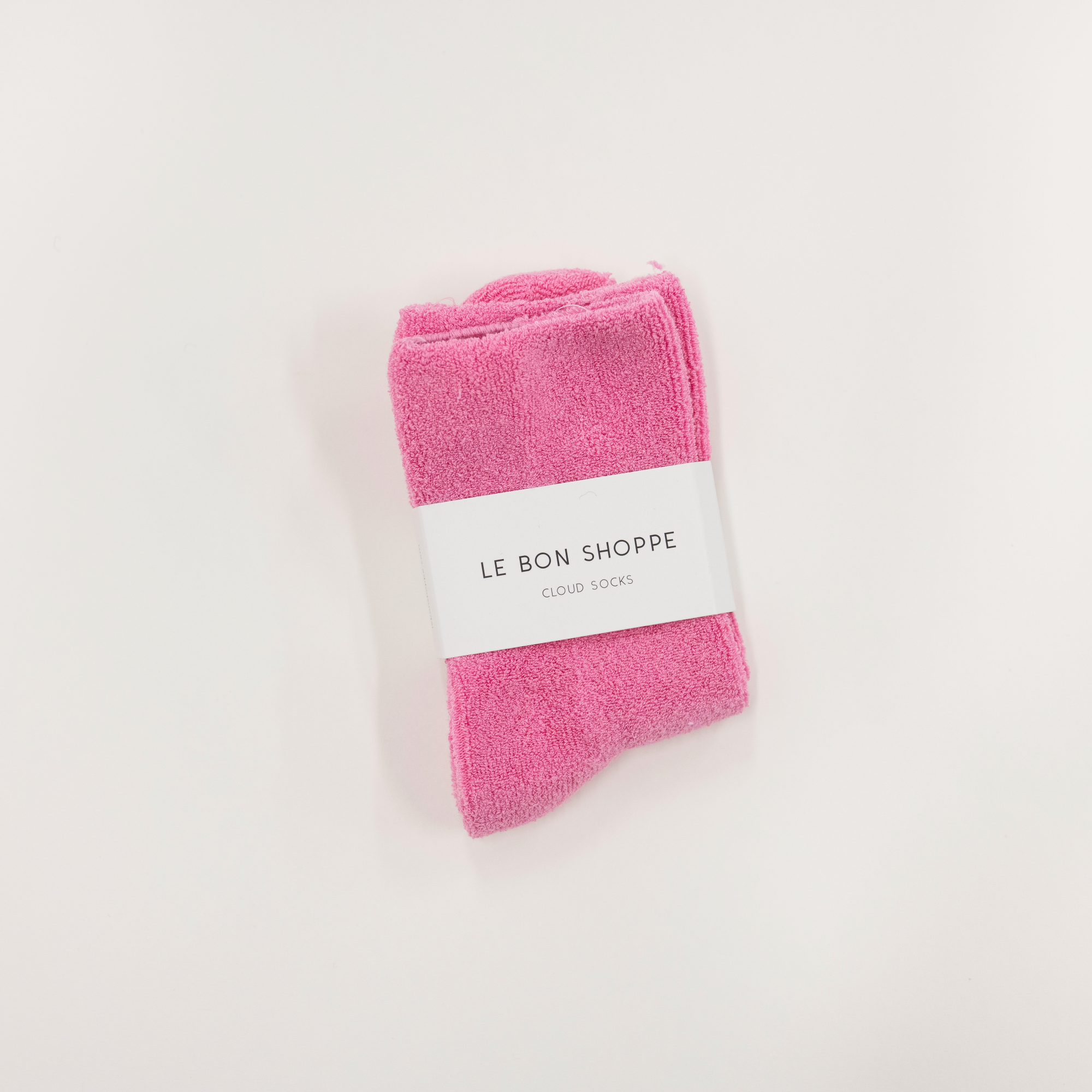 bright pink cloud socks on a white surface, each with a label indicating the brand le bon shoppe